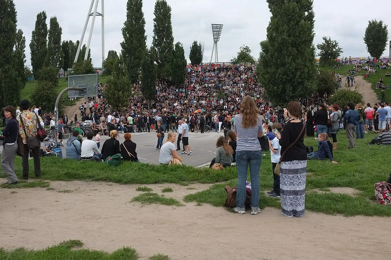 De drukke vlooienmarkt in het Mauerpark op een zonnige zondag in Berlijn, met kramen, mensen en de Berlijnse Muur op de achtergrond